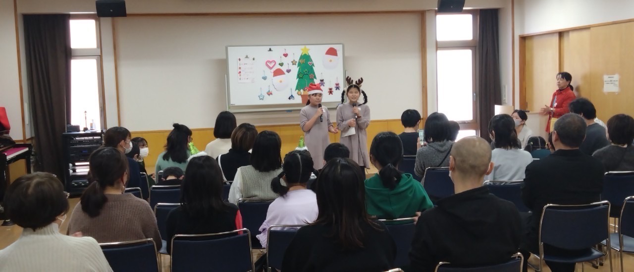 司会役の子ども2人がステージでクリスマスソングを歌う。